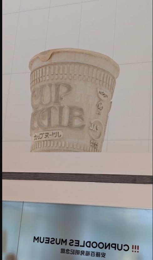 カップヌードルミュージアム横浜 安藤百福発明記念館の館名表示と巨大カップのレリーフ