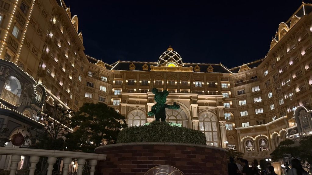 夜にライトアップされた東京ディズニーランドホテルの外観とミッキーの植栽