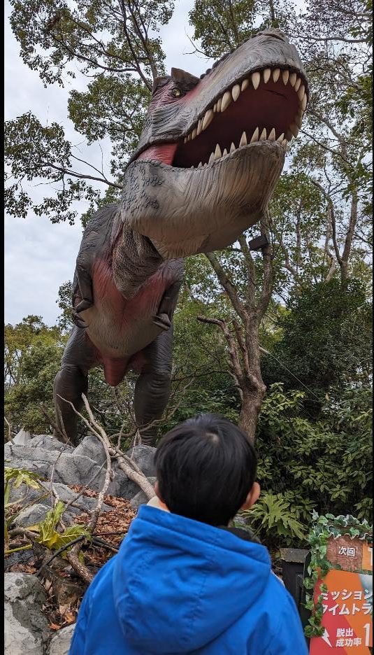 巨大な恐竜を見上げる子供(ハウステンボスのアトラクション)