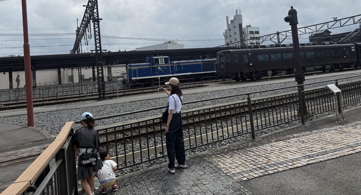 下今市駅のSL展示エリアで機関車を見学する親子